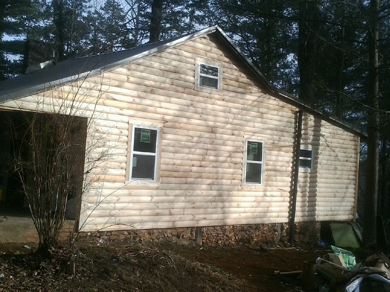 New log siding and dark metal roofing on a gable end in Winchester
